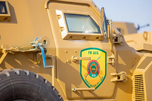 Un véhicule militaire jaune portant l’inscription 'FU-AES'