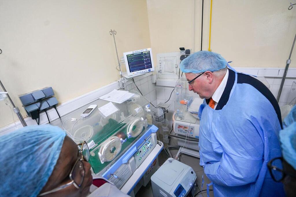 Le directeur exécutif adjoint de l'UNFPA, Andrew Saberton, vêtu d'une tenue médicale, observe un incubateur dans une maternité du Tchad.