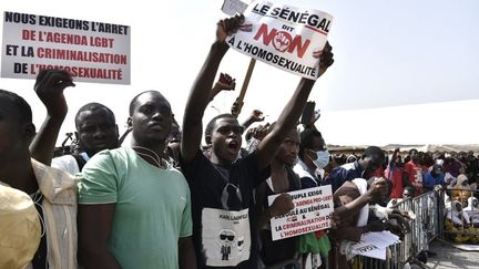 Des manifestants brandissent des pancartes lors d'une manifestation à Dakar en février 2022, réclamant un durcissement de la répression contre l'homosexualité.