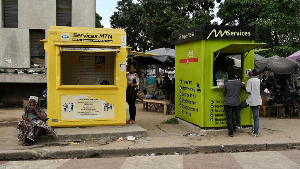 Agents de mobile money en pleine transaction à Abidjan, Côte d'Ivoire.